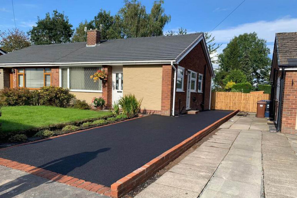 black ashphalt drive with retaining wall